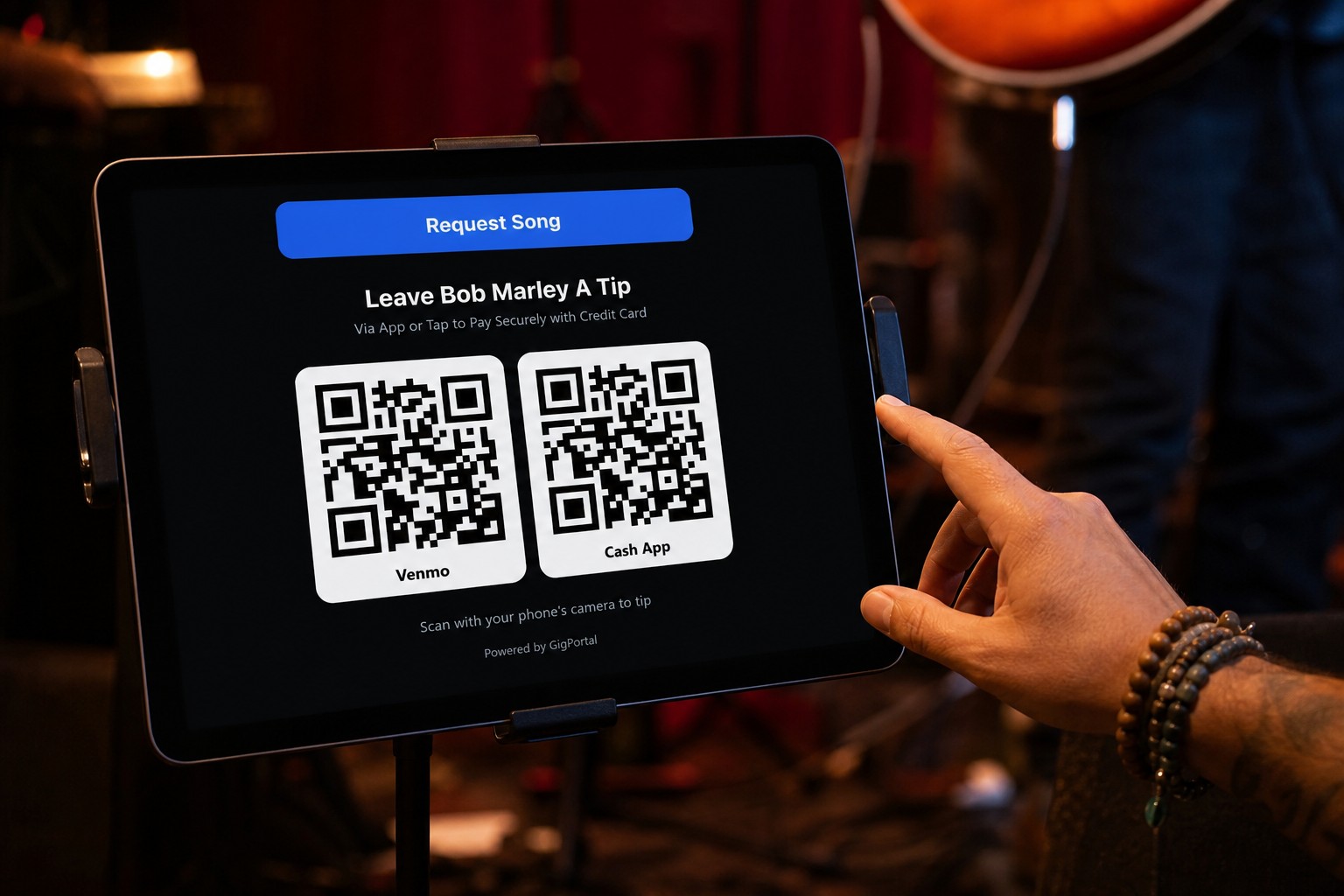 Performer reaching toward an iPad tip station with a Request Song button above Venmo and Cash App QR codes